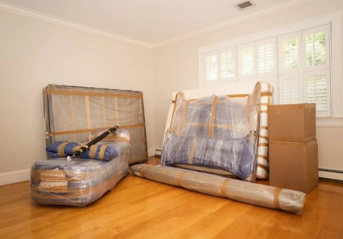 Shrink-wrapped sofa and mattress ready to load
