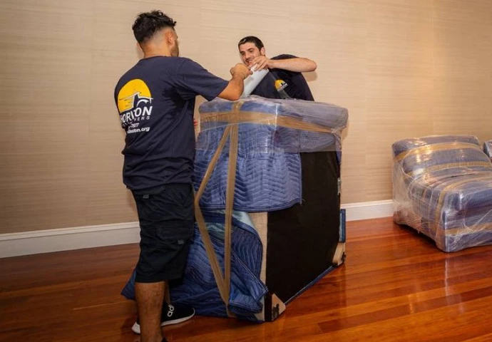 Horizon movers wrapping and strapping a padded armchair